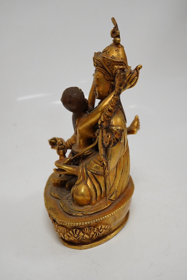 A Tibetan gilt bronze figure of a deity and consort, 15cm high. Condition - good